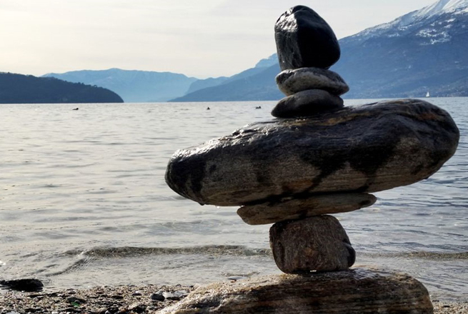 stacked rocks by a lake – creating balance in a moving world